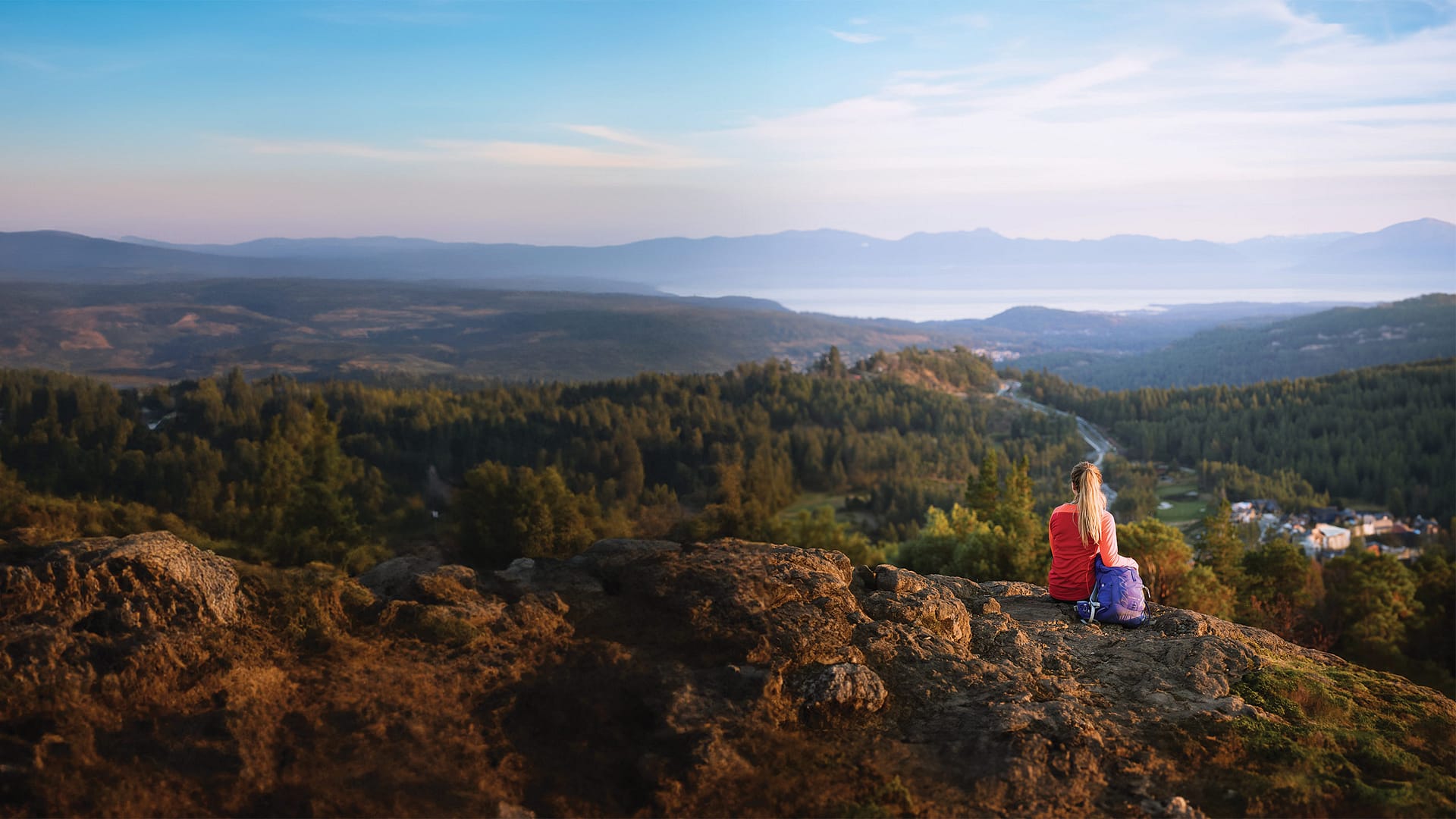 Woman sitting on top of Mount Wells for the Strategic Plan